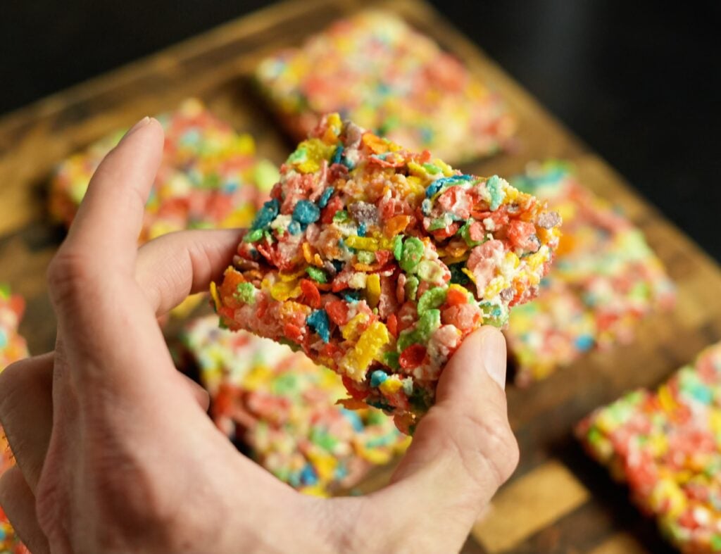 Protein Fruity Pebbles Rice Crispy Treats in hand close up wide