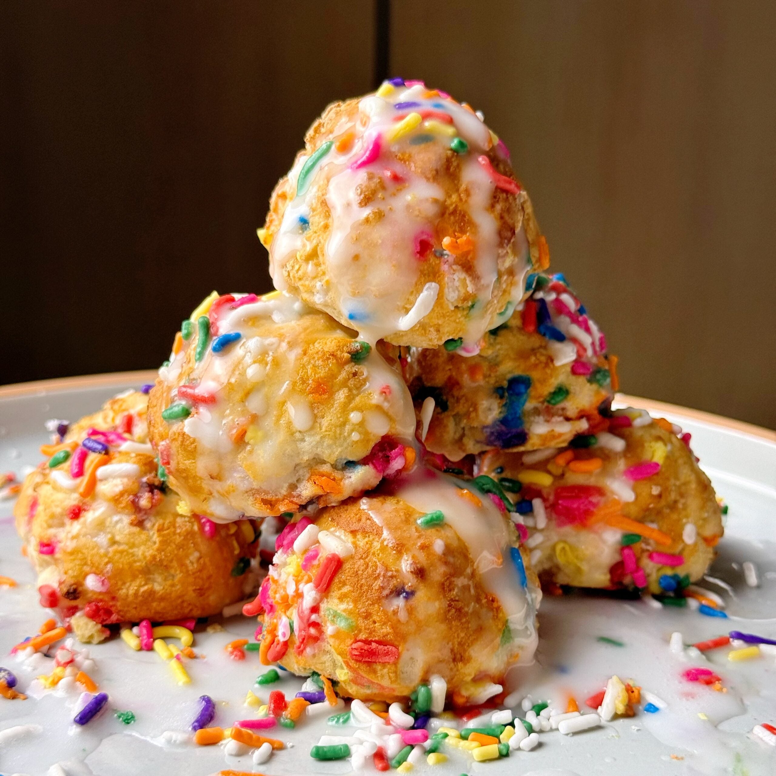 close up birthday cake donut holes on plate stacked