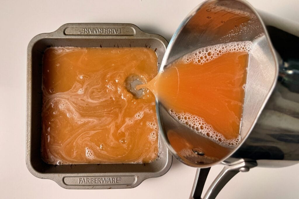 pink gelatin being poured into pan
