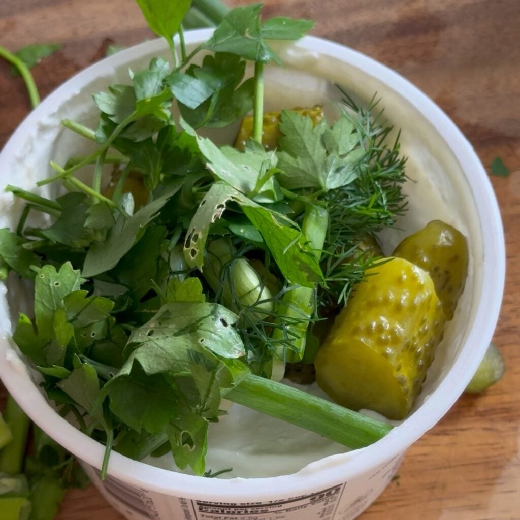 adding pickles and herbs