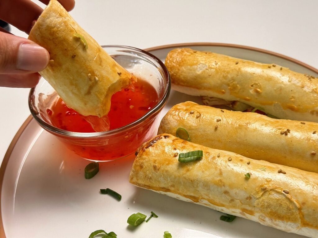high protein low carb crab rangoons in hand dipping