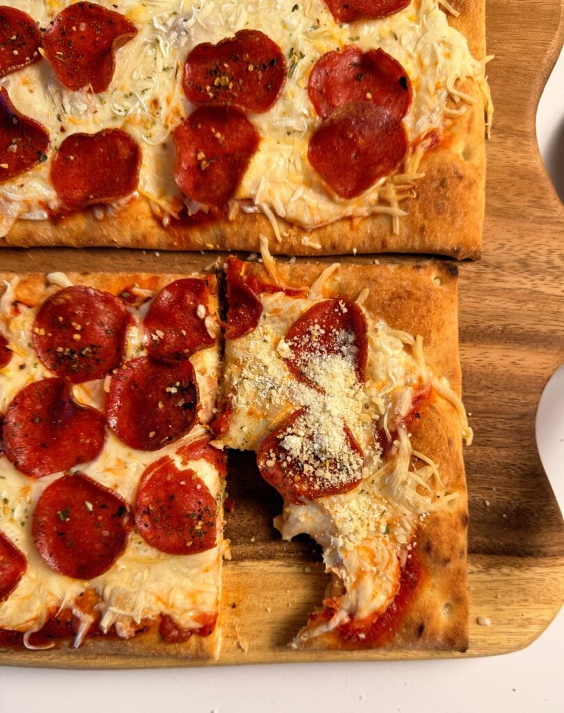 holding high protein pepperoni pizza slice