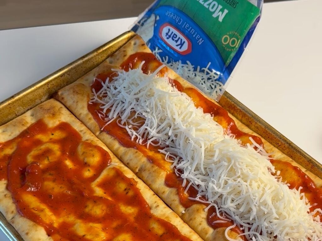 spreading cheese on healthy pepperoni pizza