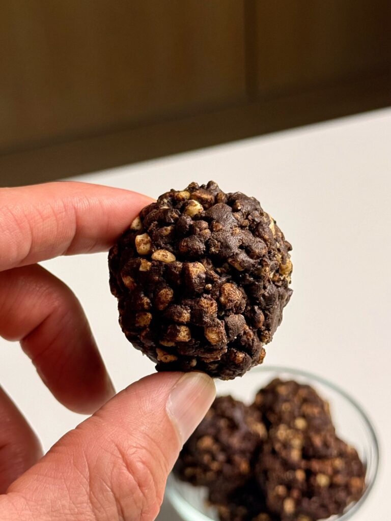 finger holding chocolate protein truffle