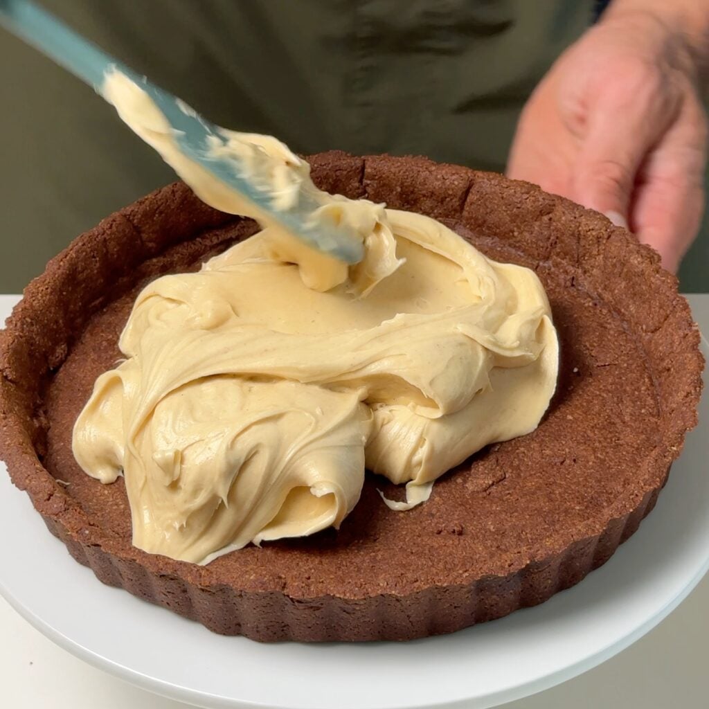 peanut butter tart with chocolate ganache adding filling