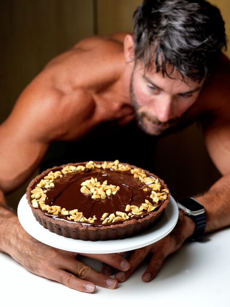 peanut butter tart with chocolate ganache holding by jacob