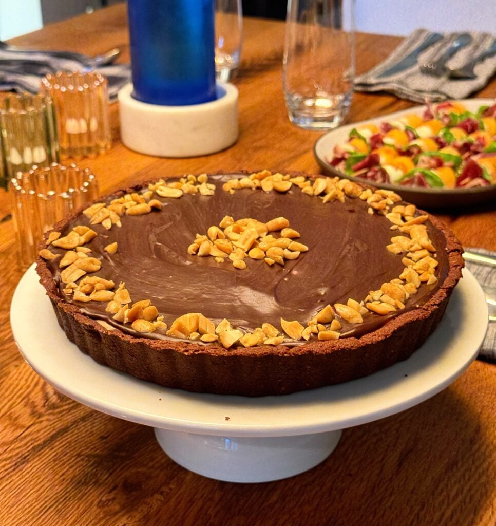 peanut butter tart with chocolate ganache on table