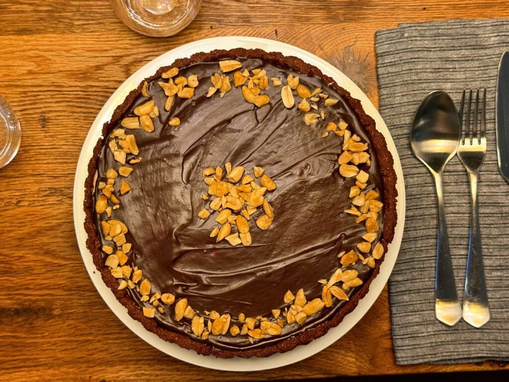 peanut butter tart with chocolate ganache on table for dinner