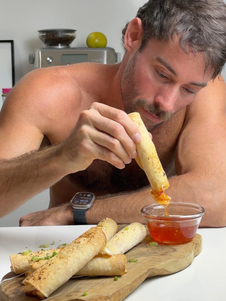 Jacob dipping a crab rangoon mozzarella taquito into sweet chili sauce beside the finished taquitos.
