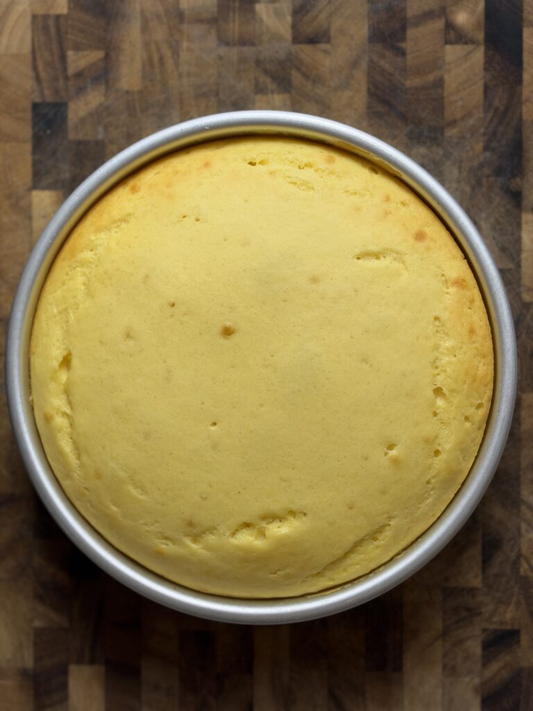Overhead view of baked pineapple protein cake in an 8-inch pan before it is inverted.