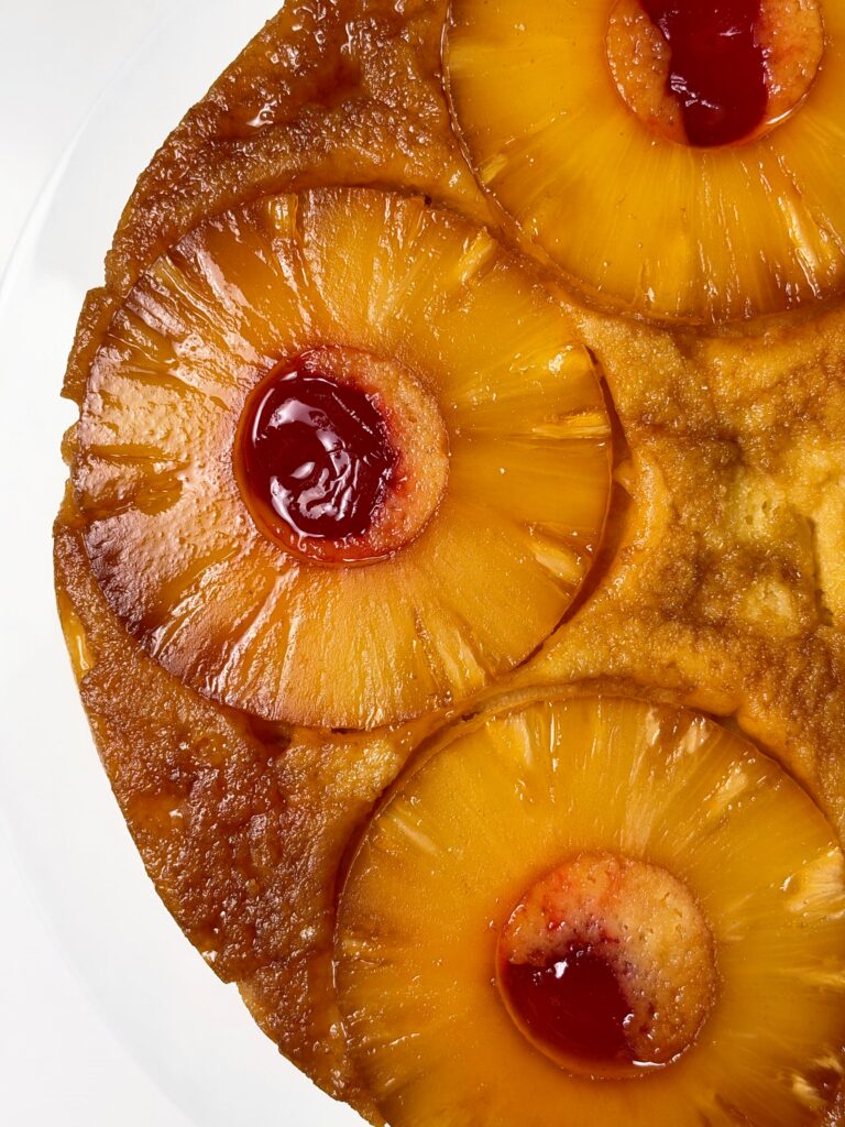 Overhead close-up of caramelized pineapple rings and cherries on high-protein pineapple upside-down cake.