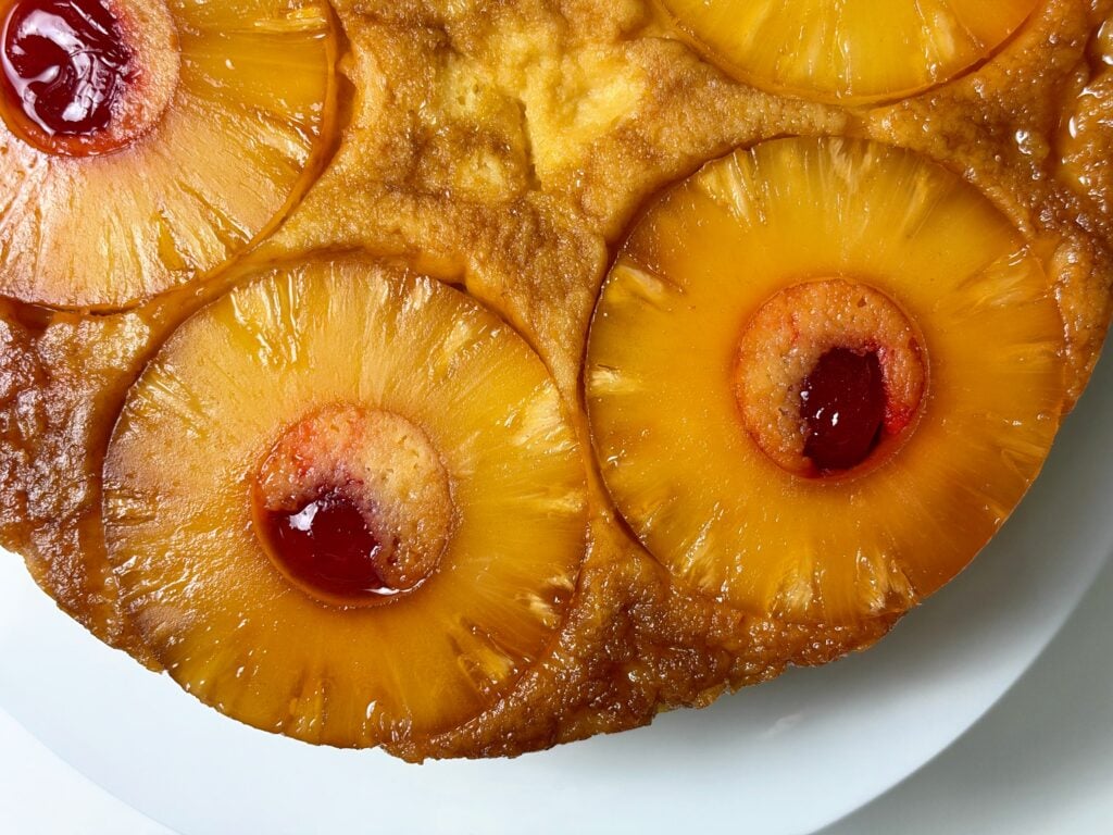 Close-up of caramelized pineapple rings and maraschino cherries on pineapple upside-down protein cake.
