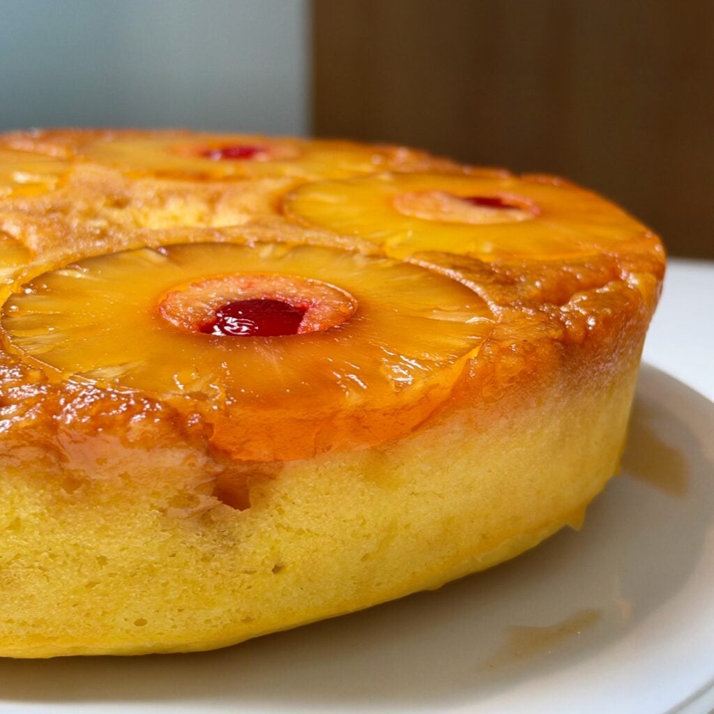 Close-up of high-protein pineapple upside-down cake with caramelized pineapple rings and maraschino cherries.