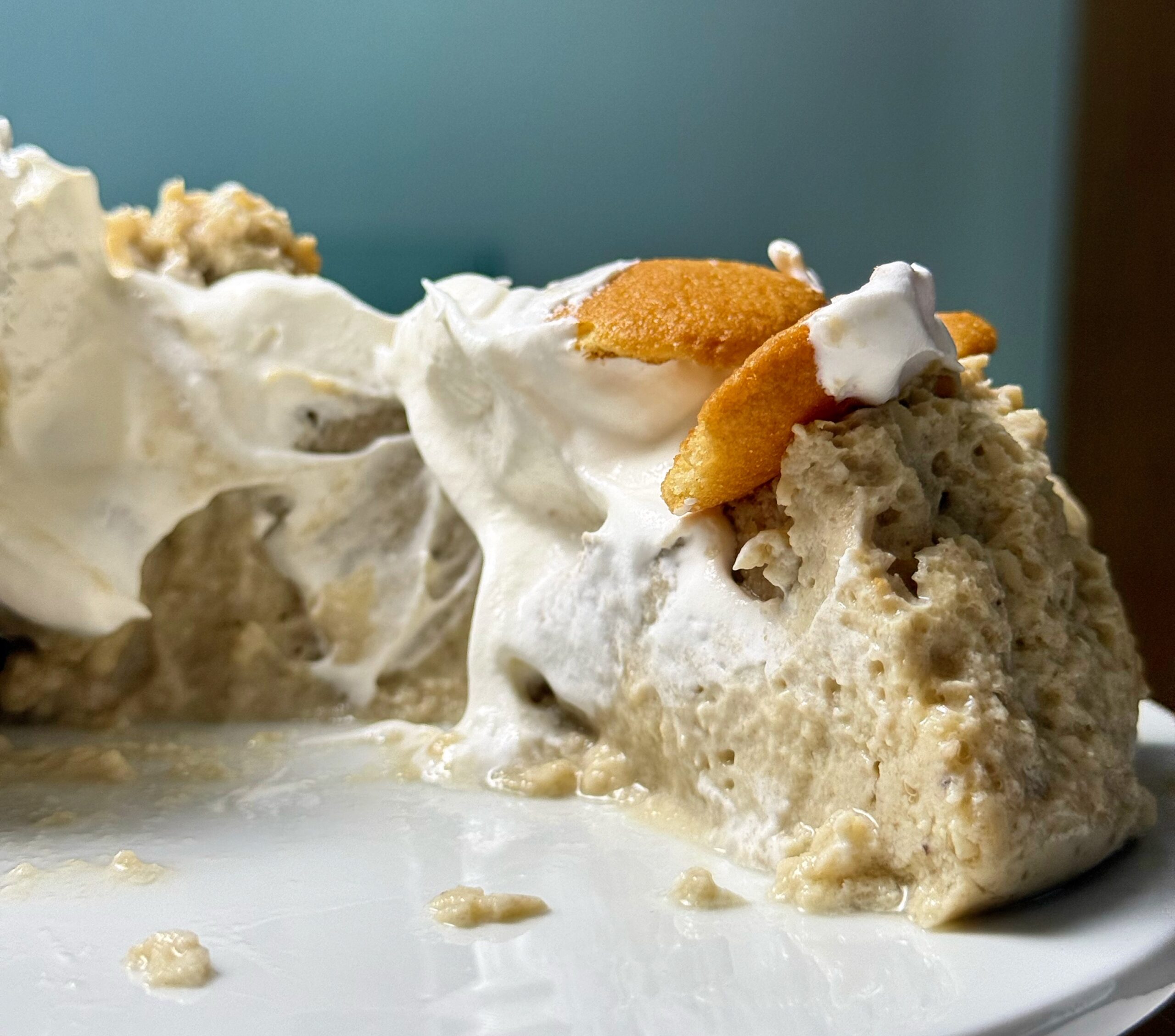 Close-up of the creamy interior of banana cream cheesecake with whipped cream and vanilla wafers.