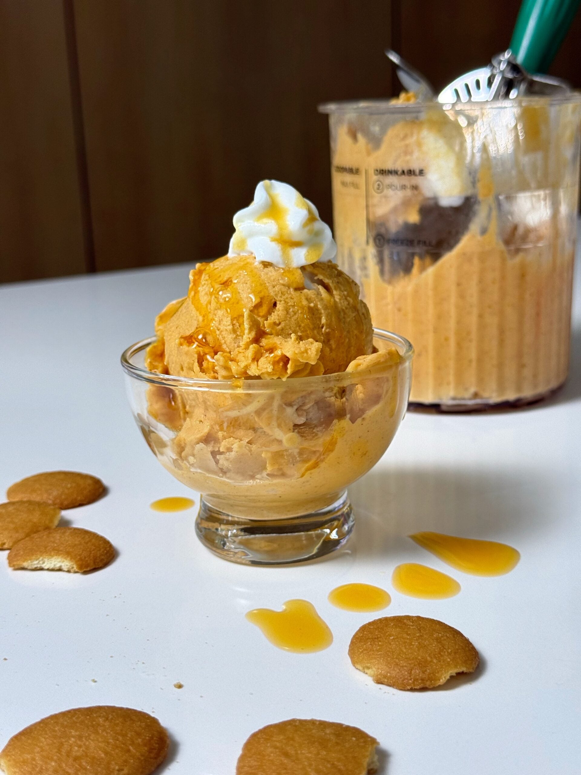 High-protein pumpkin pie Ninja Creami in a dessert bowl with the pint container behind it