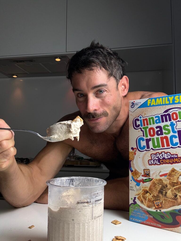 Jacob Hensley holding a spoonful of high-protein Cinnamon Toast Crunch Ninja Creami beside the pint and cereal box.
