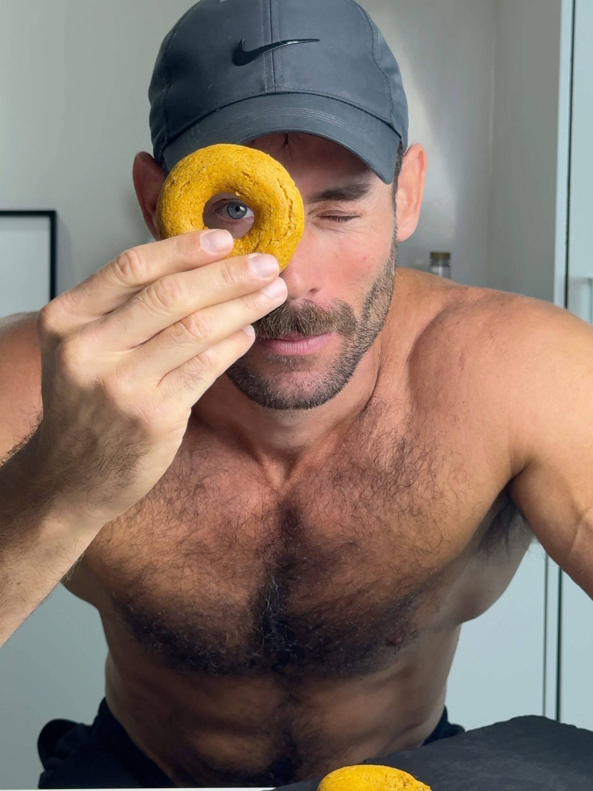 Jacob holding a baked pumpkin spice donut in front of his eye