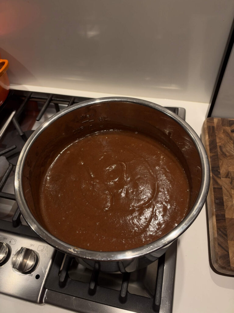 Smooth blended apple butter in a large cooking pot before the final thickening step.