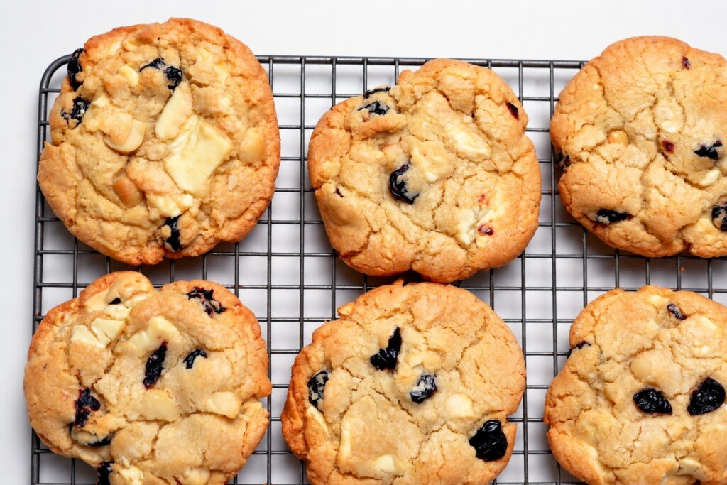 Close view of gluten-free white chocolate cherry almond cookies on a cooling rack.