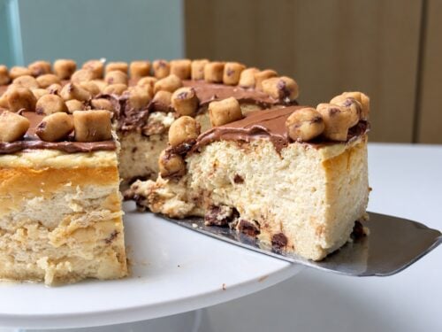 Whole cookie dough cheesecake beside a plated slice