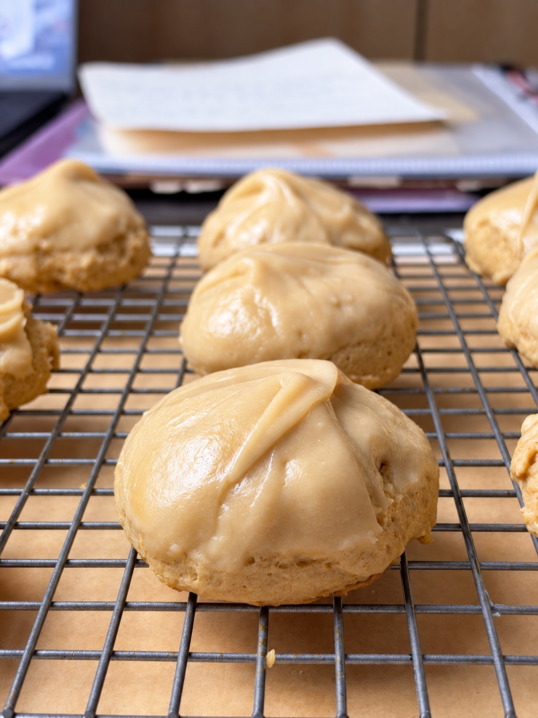 Close-up of thick frosted brown sugar cookies resting on a wire cooling rack