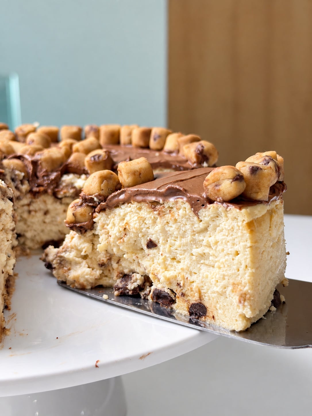 Slice of cookie dough cheesecake lifted on a cake server
