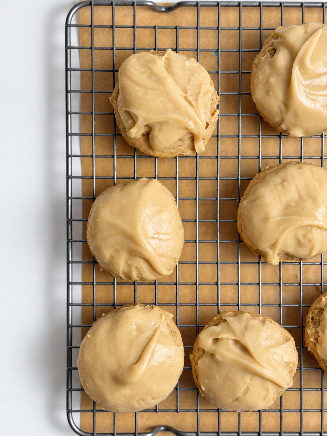 Overhead detail of frosted brown sugar cookies arranged on a wire rack