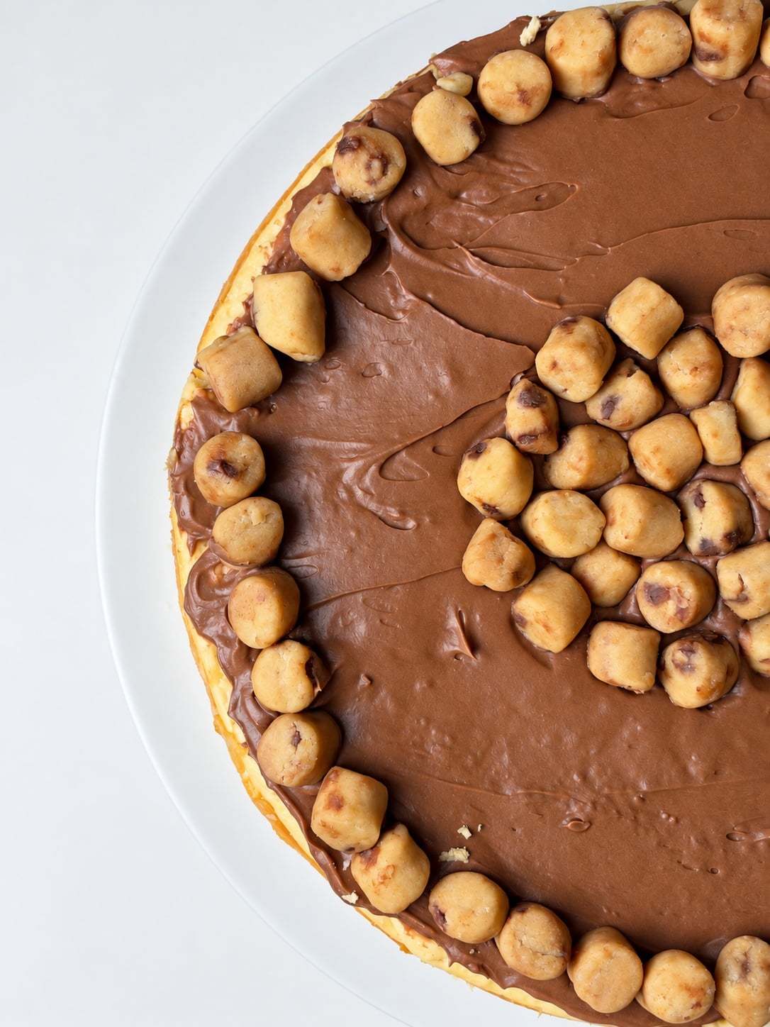 Close-up of protein cookie dough pieces and chocolate chips on cheesecake