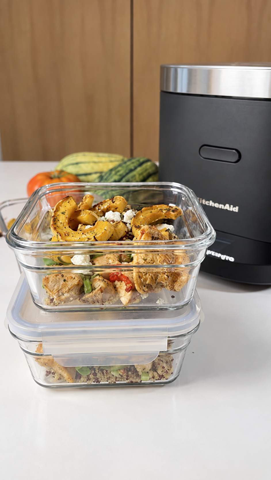 Glass meal-prep containers filled with chicken, quinoa, delicata squash, peppers, cranberries, walnuts, and blue cheese.