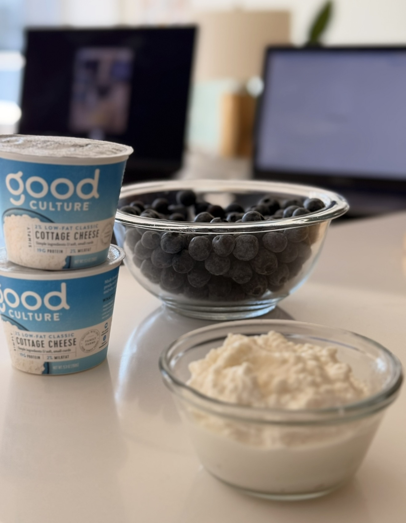 Good Culture cottage cheese, fresh blueberries, and flour arranged for blueberry cottage cheese muffins