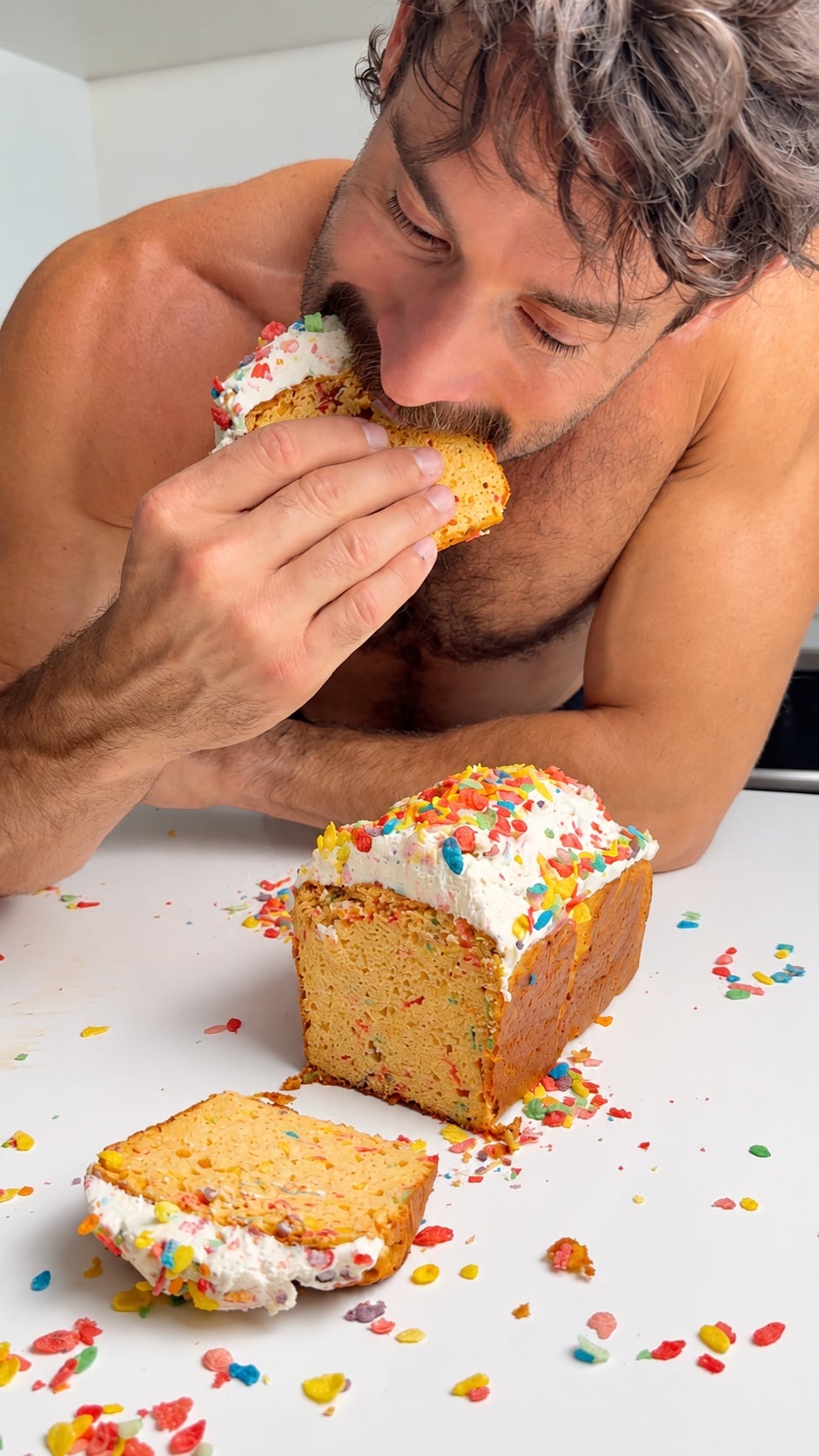 Jacob taking a bite of a frosted Fruity Pebbles protein loaf cake slice