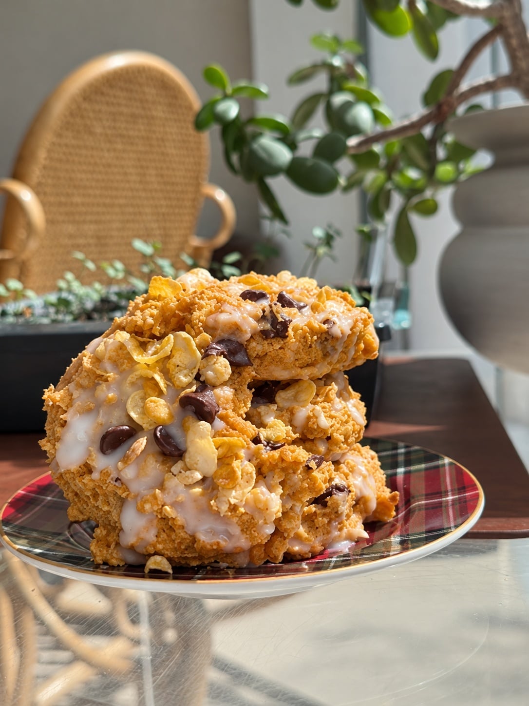 Glazed pumpkin corn flake protein breakfast cookies stacked on a plaid plate