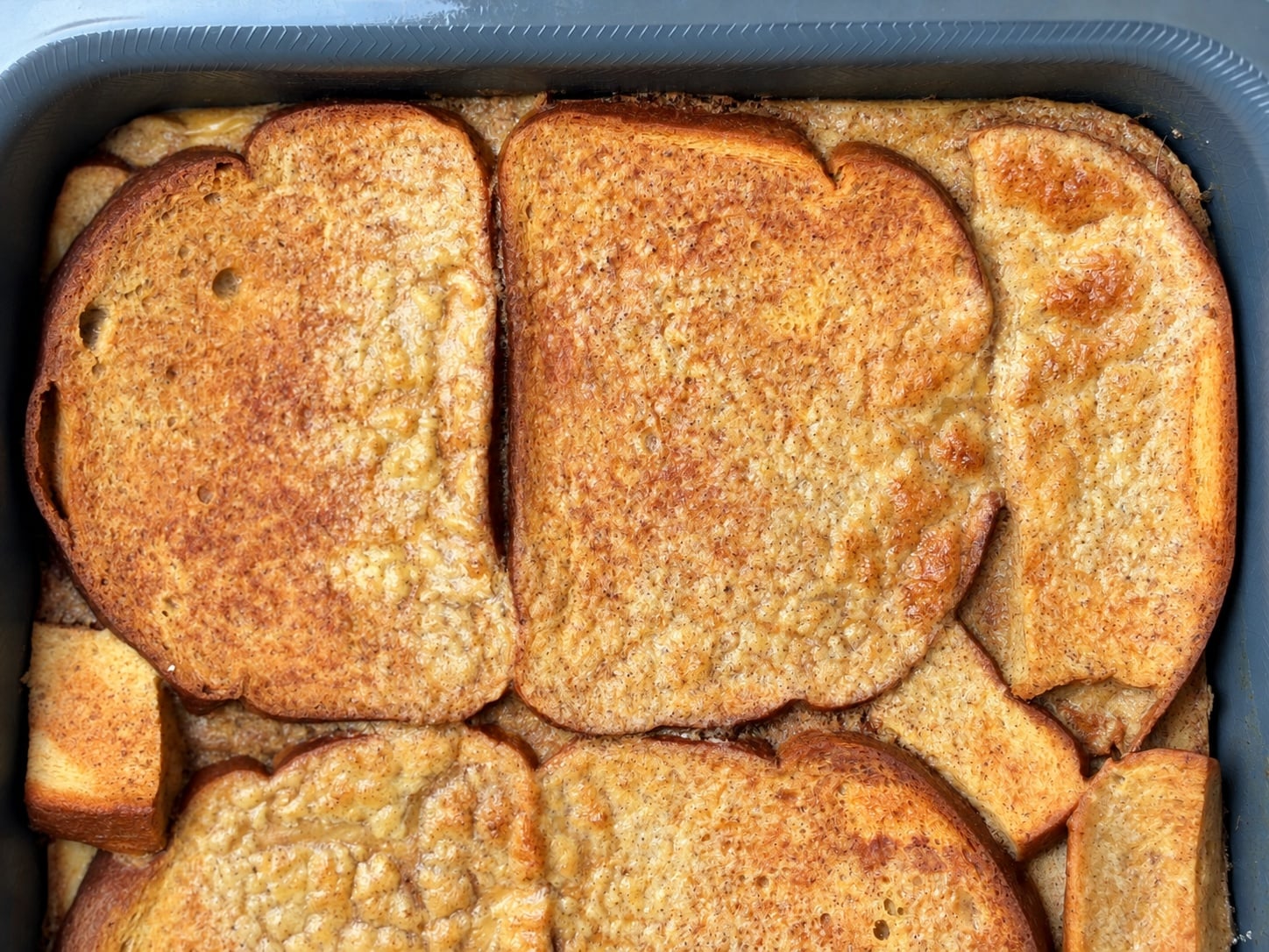 Close-up of the freshly baked high-protein French toast casserole with golden bread slices in the baking pan.