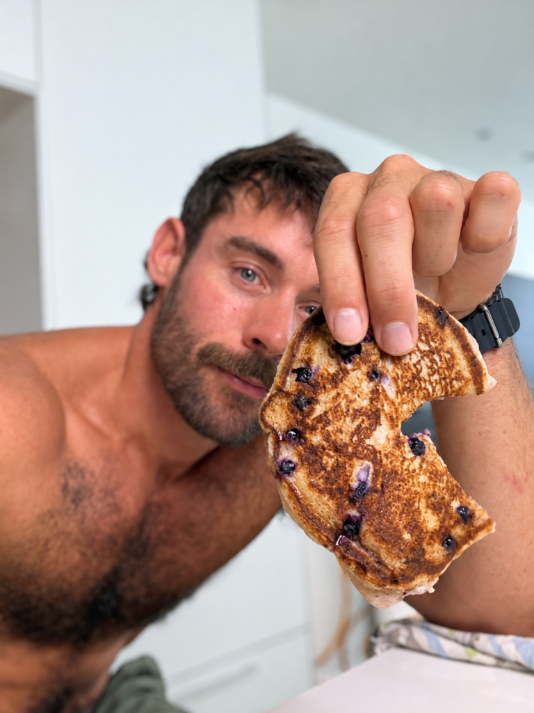 Jacob holding a blueberry pancake with a bite taken out