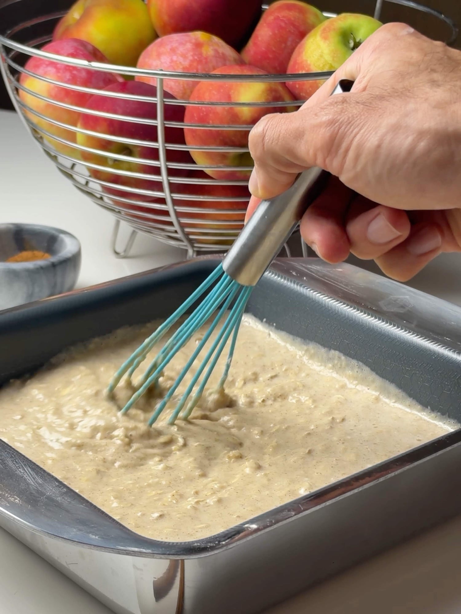 Mixing the apple pie baked oatmeal batter in an 8×8-inch baking pan