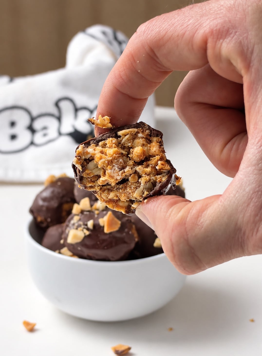 Bitten chocolate peanut butter protein truffle showing the oat and soy protein puff center