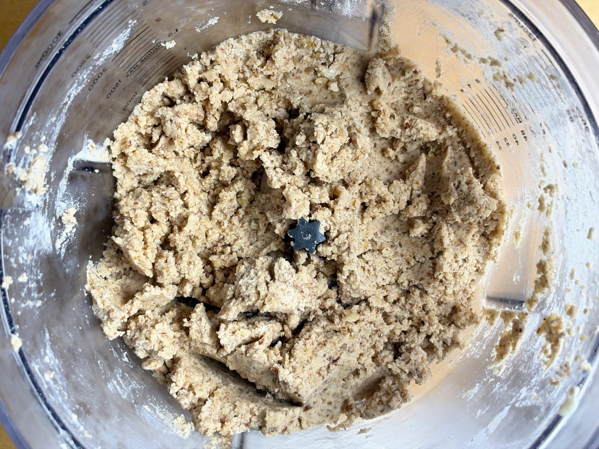 Pecan crescent cookie dough forming moist clumps in a food processor