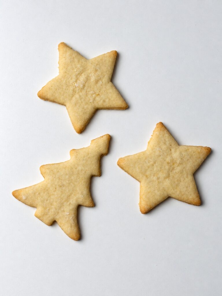Plain baked cream cheese cut out cookies in tree and bell shapes
