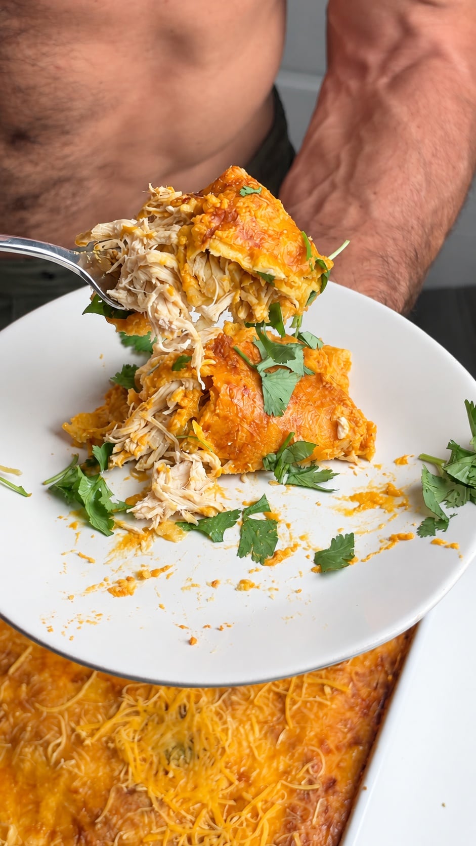Forkful of pumpkin chicken enchilada showing shredded chicken and corn tortilla