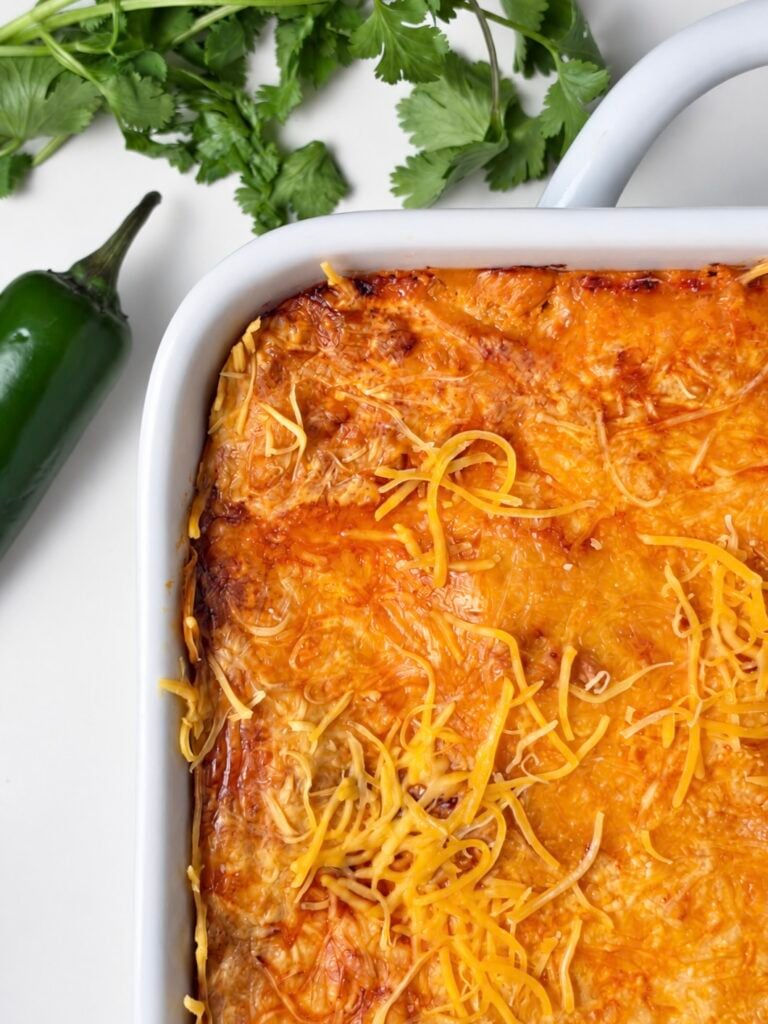 Close-up of browned melted cheese on pumpkin chicken enchiladas