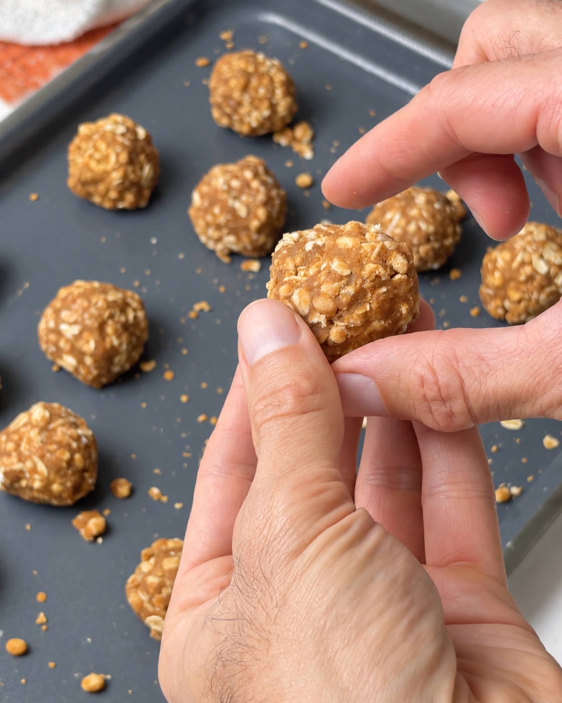 Shaping peanut butter oat mixture into protein truffle balls by hand