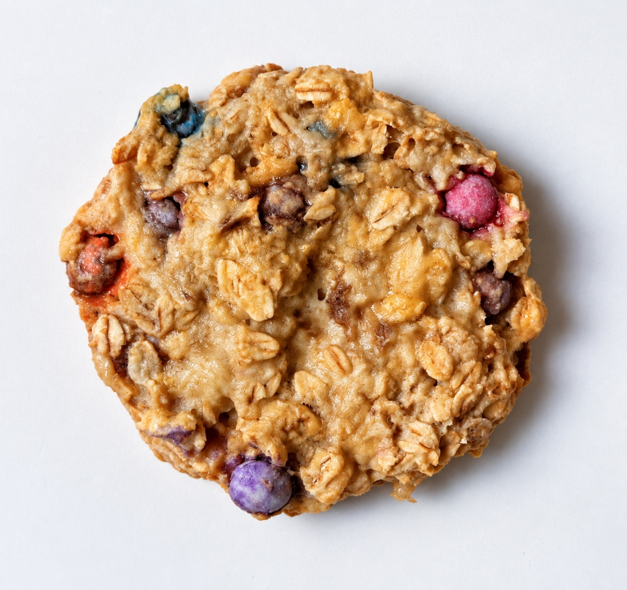 Single banana oatmeal M&M breakfast cookie on a white background