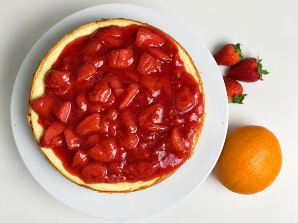 Overhead view of strawberry orange protein cheesecake topped with chunky strawberry compote.
