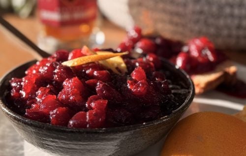 Bourbon cranberry sauce served in a small bowl with lemon peel on top