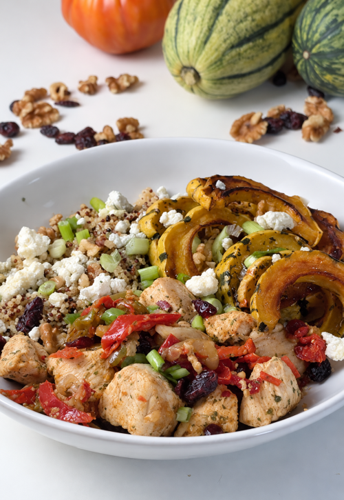 Fall harvest chicken quinoa bowl with roasted delicata squash, peppers, cranberries, walnuts, and blue cheese.