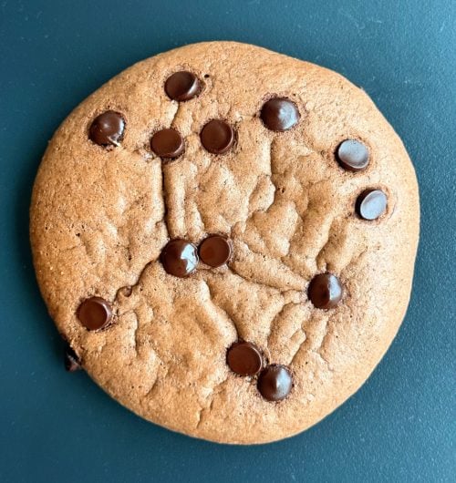 Extreme close-up of the crinkle top and melted chocolate chips on a high protein brownie cookie.