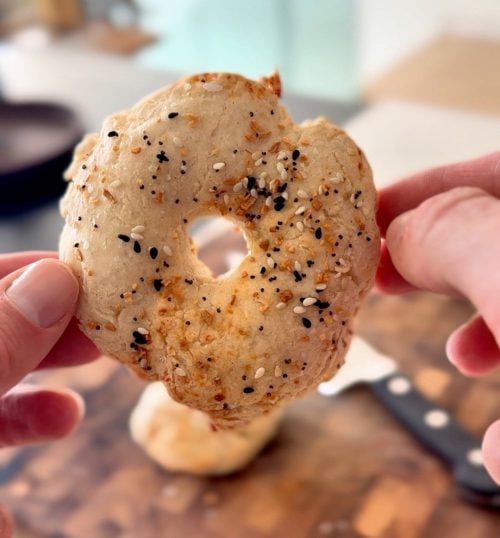Gluten-free cottage cheese bagel held in hands showing soft interior texture