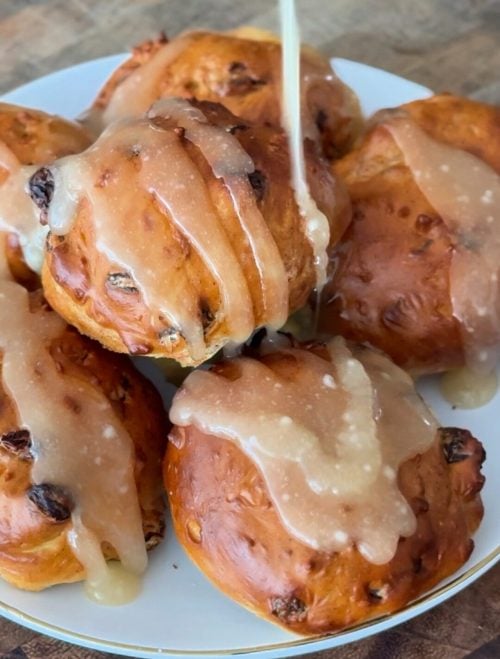 A tall stack of air-fried cinnamon raisin bagel bites showing a golden, slightly textured exterior on a white plate.