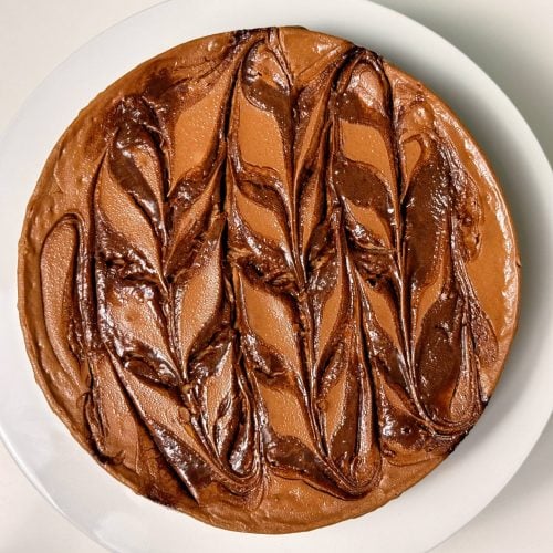 high protein double chocolate cheesecake wide shot on counter not sliced