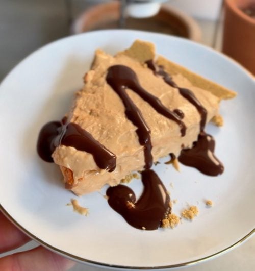 Slice of high-protein peanut butter pie with chocolate drizzle